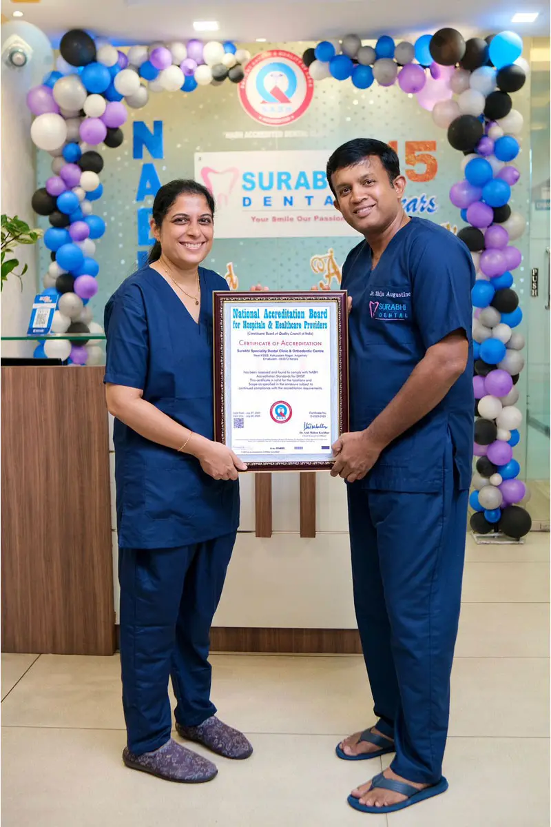 Staff holding a 15-year anniversary certificate at Best Dental Clinic in Angamaly, Kerala.
